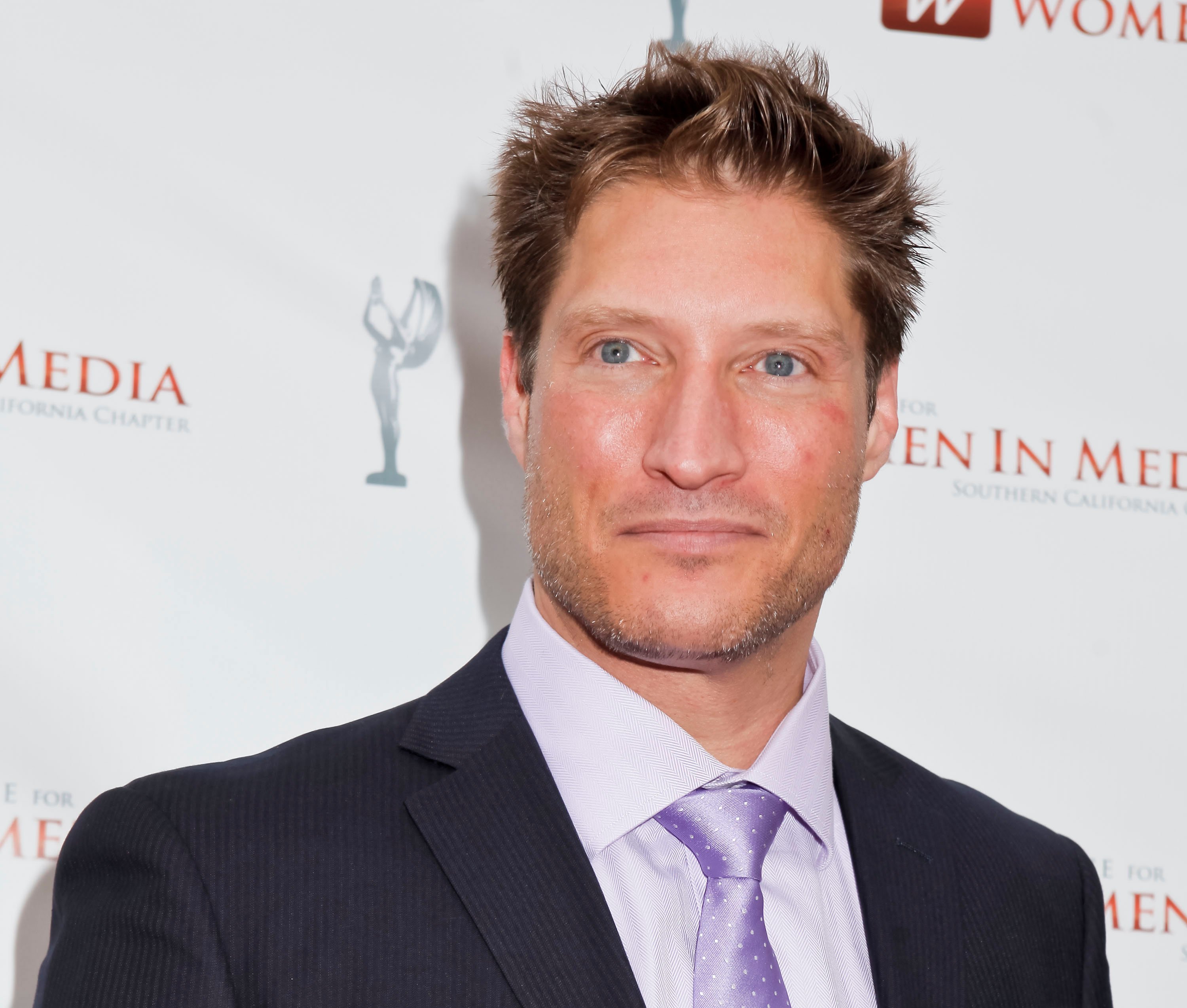 'The Bold and the Beautiful' actor Sean Kanan wearing a black suit, white shirt, and lavender tie.