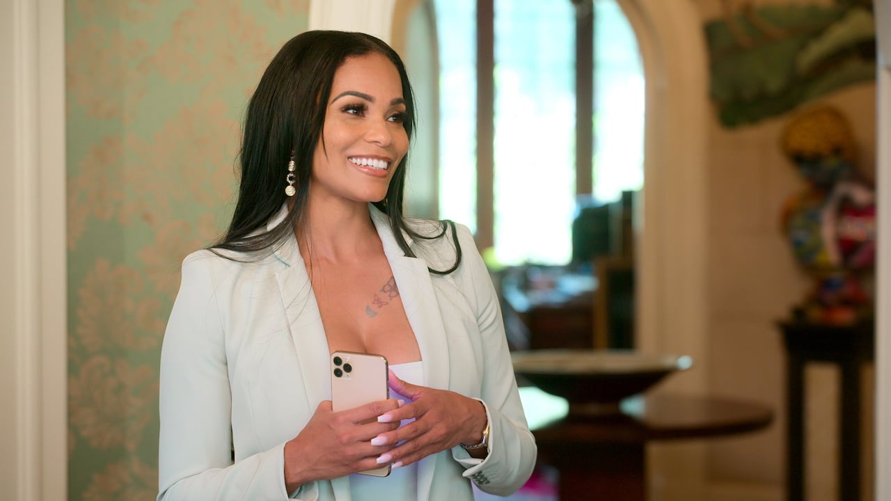 Sharelle Rosado on 'Selling Tampa' smiles holding a phone.