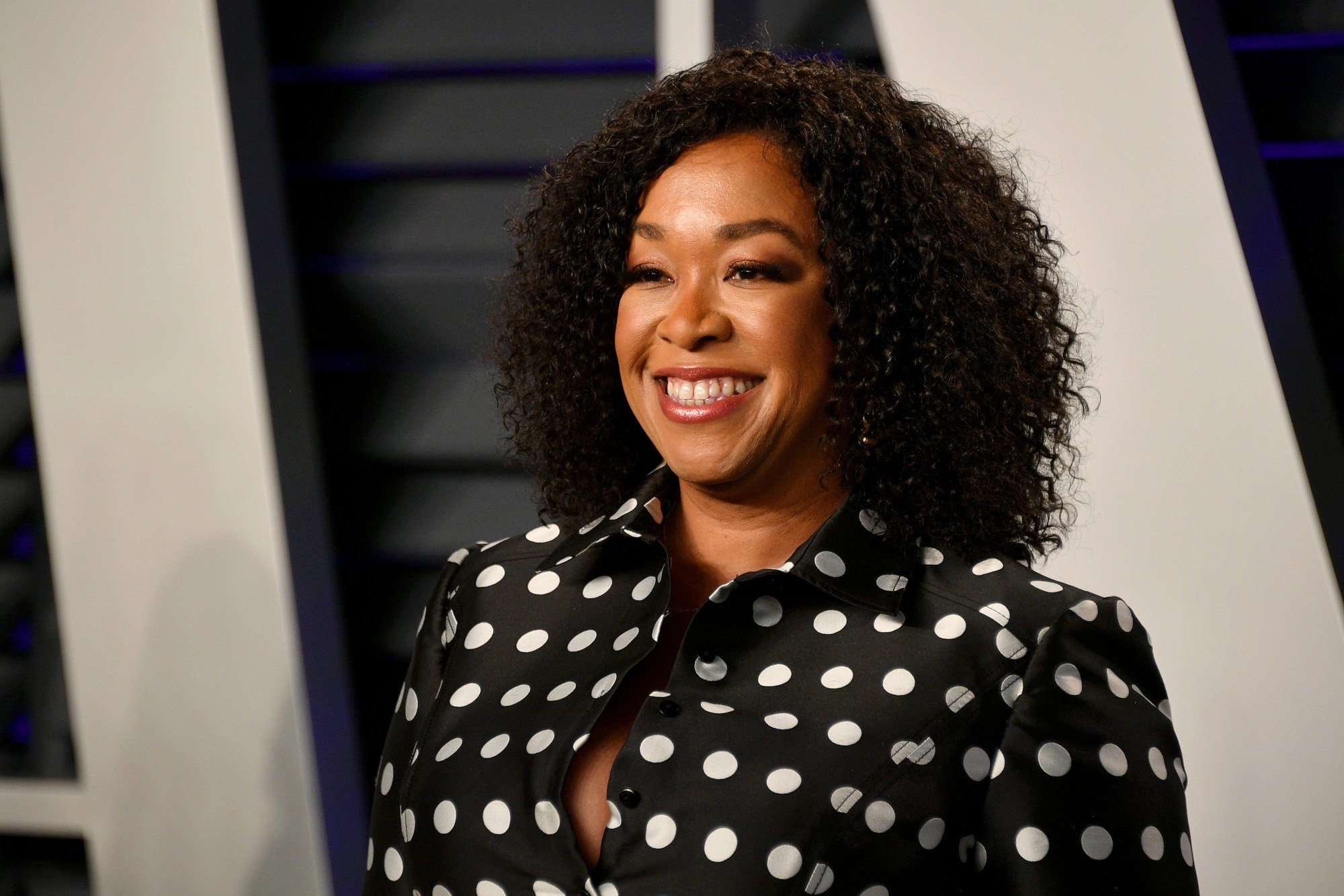 'Grey's Anatomy' creator Shonda Rhimes attending Vanity Fair's Oscar Party. Her hair is curled, and she's wearing a black dress with white polkadots.