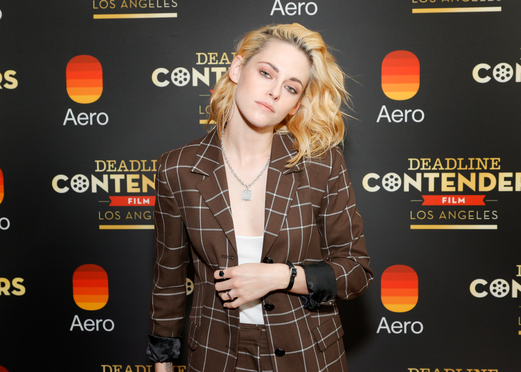 'Spencer' star Kristen Stewart wearing a brown jacket and pants in front of a step and repeat