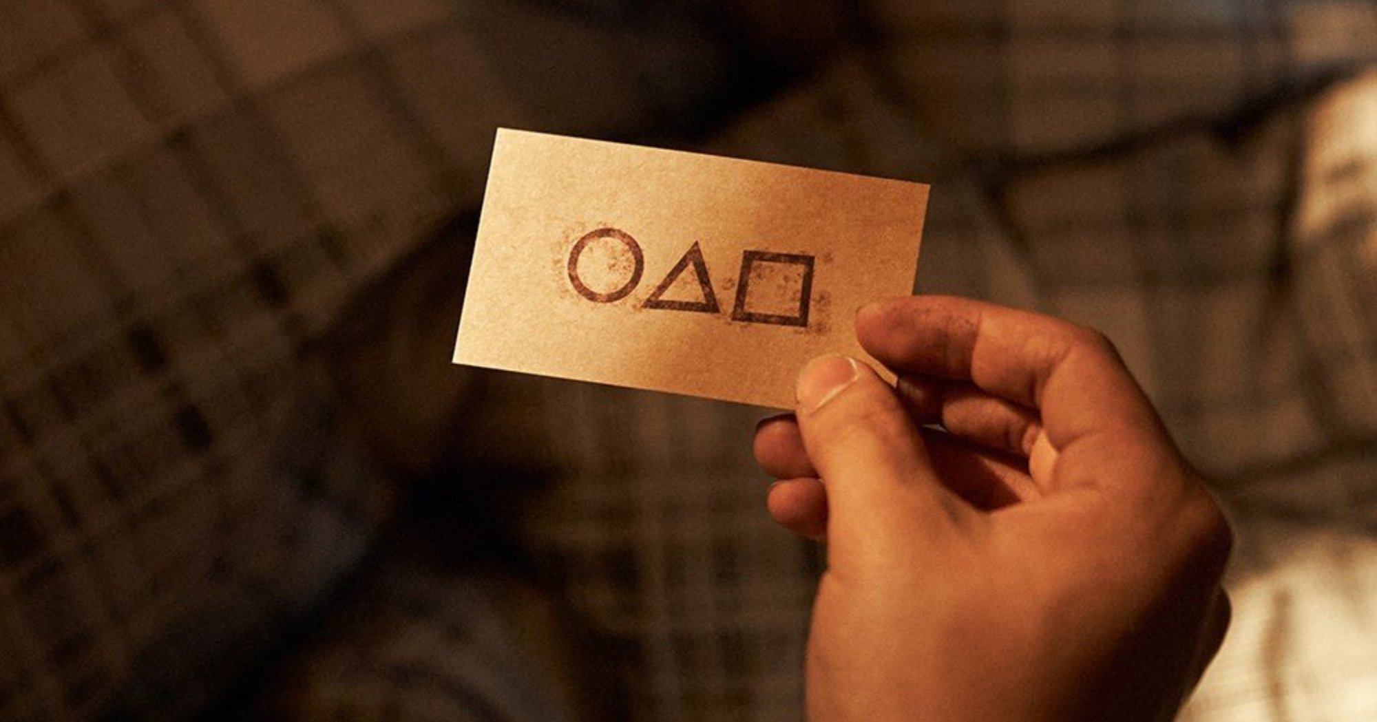 Someone holding 'Squid Game' calling card still image from K-drama