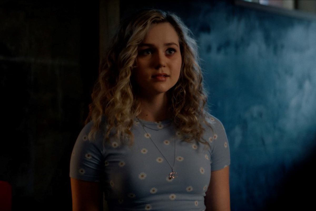 'Stargirl' actor Brec Bassinger, in character as Courtney Whitmore, wears a light blue short-sleeved shirt with white daisies.