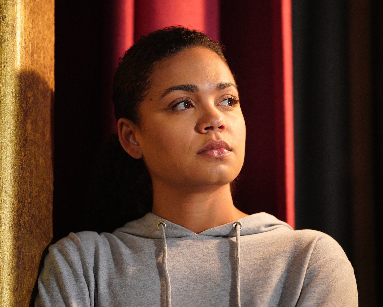 BARRETT DOSS as Victoria Hughes on 'Station 19' looks to the side wearing a sweatshirt.