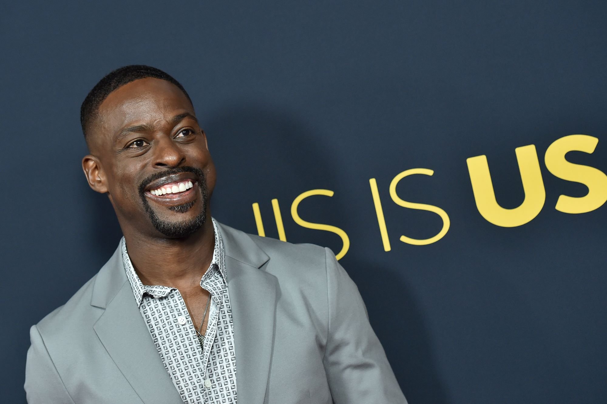 'This Is Us' Season 6 star Sterling K. Brown, who appears in the flash-forward scenes, wears a gray suit over a white patterned button-up shirt.