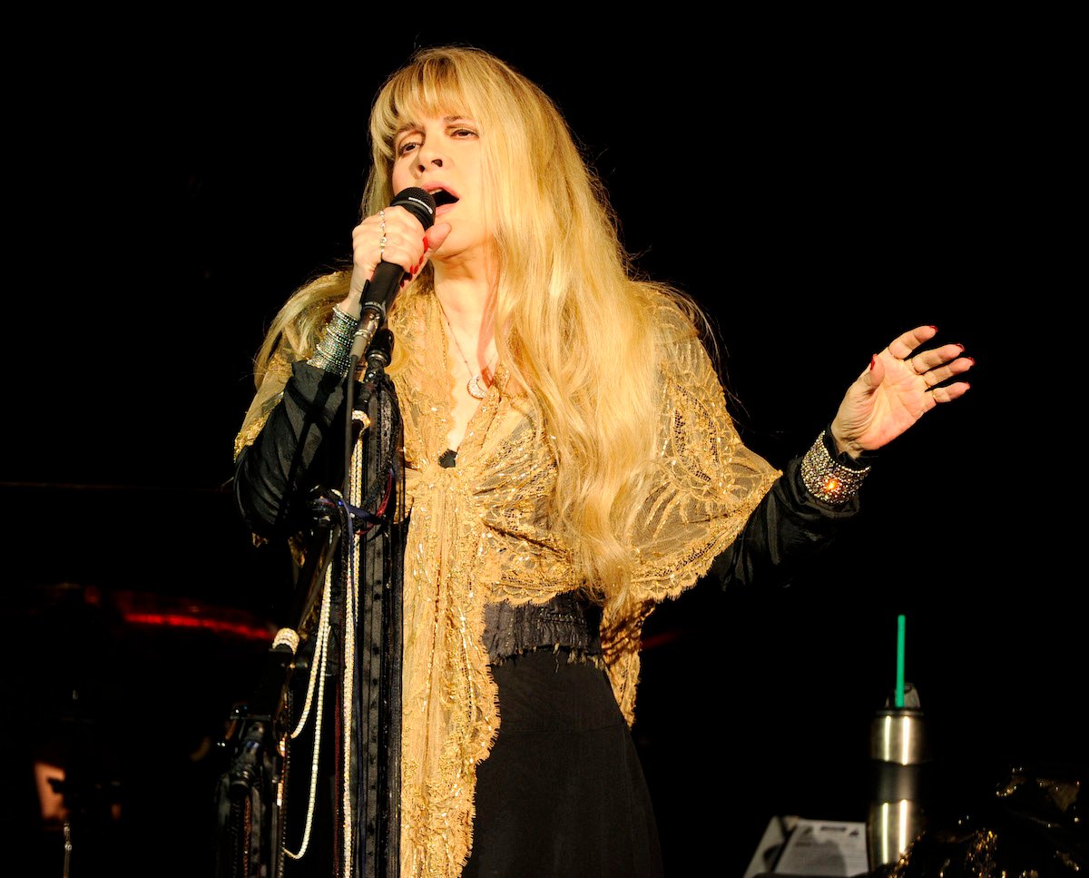 Stevie Nicks performs on stage wearing a shawl.