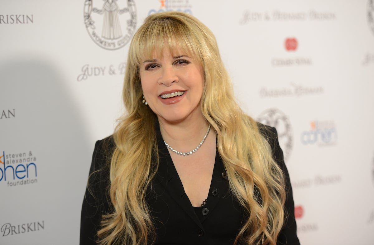 Stevie Nicks smiles for the camera at an event.
