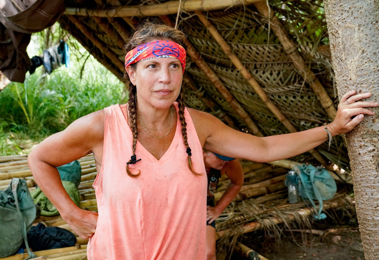 Tiffany Seely on 'Survivor' is at camp wearing a tank top and her buff.