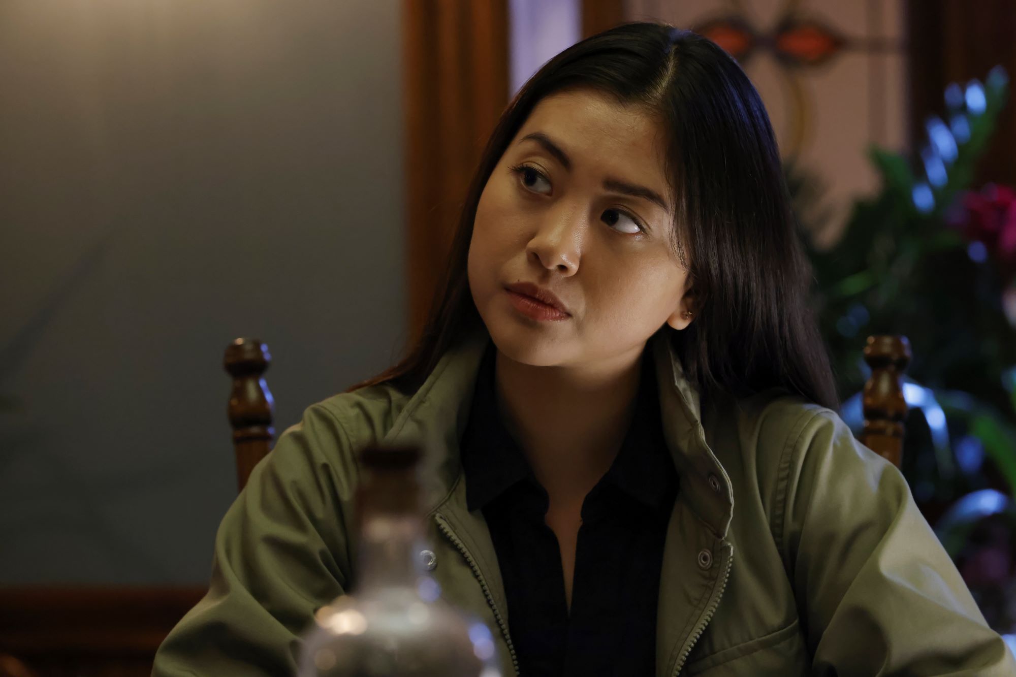 'The Blacklist' Season 9 star Laura Sohn, in character as Alina Park, wears a green jacket over a black shirt.
