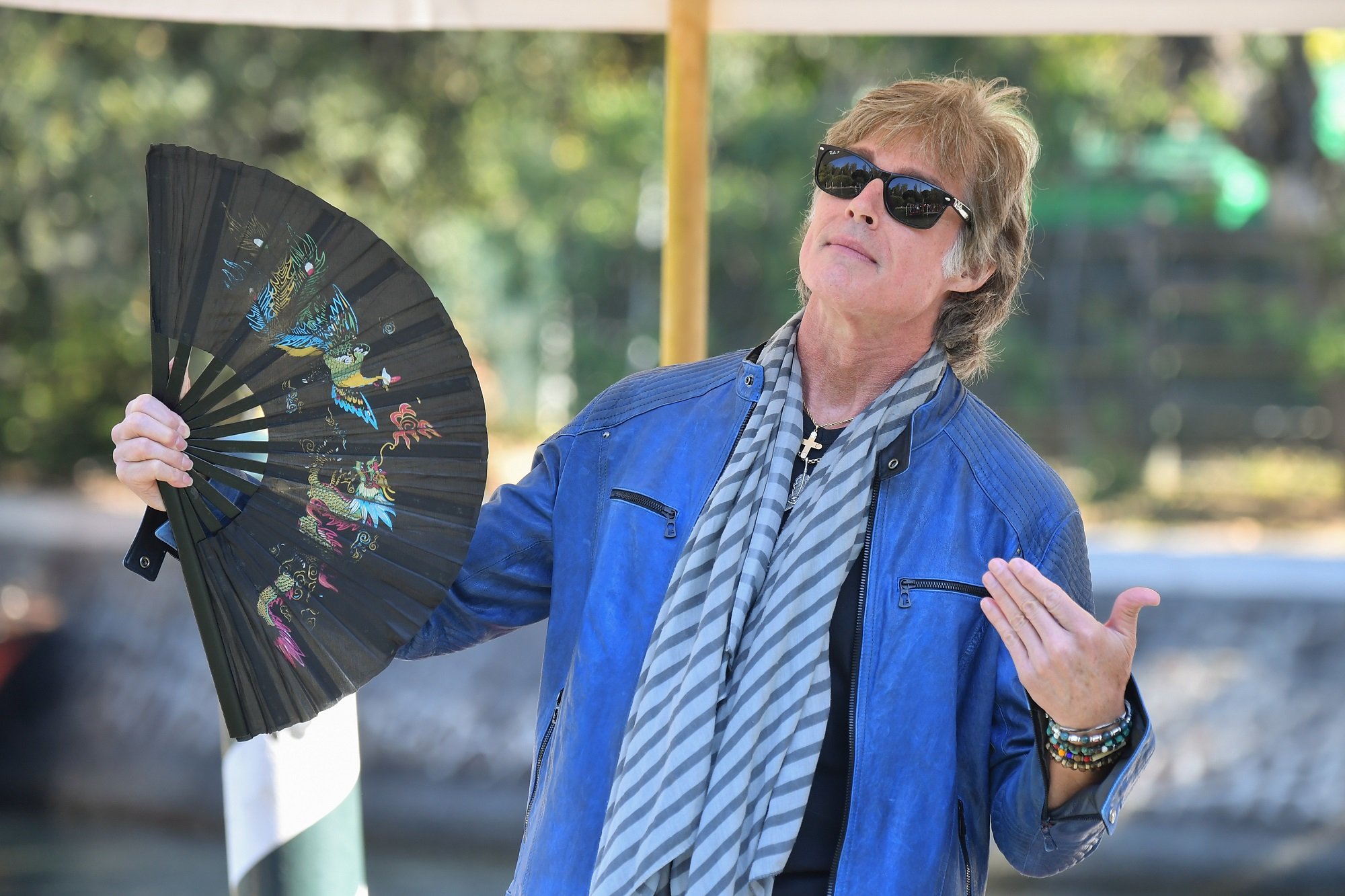 The Bold and the Beautiful star Ronn Moss, pictured here in a blue blazer and holding a fan