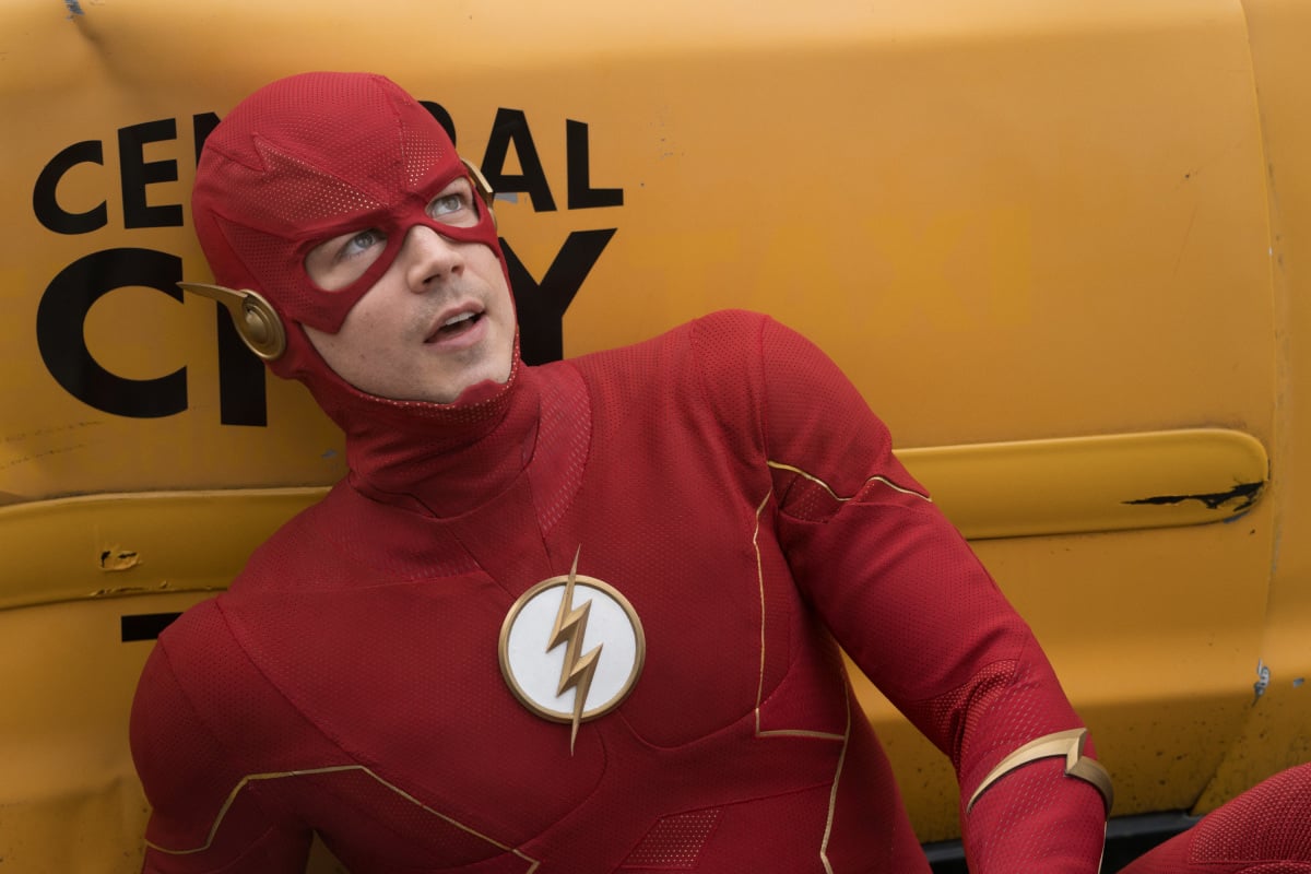 'The Flash' Season 8 star Grant Gustin, in character as Barry Allen, dons his red and gold Flash costume, and he leans against a Central City taxi.