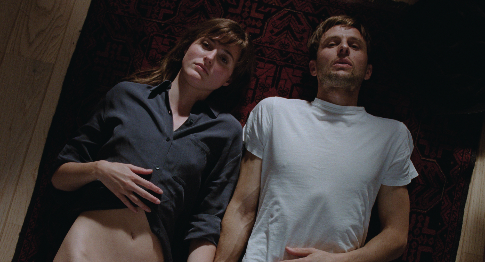 'The Worst Person in the World' review stars Renate Reinsve as Julie and Anders Danielsen Lie as Aksel laying on the ground next to each other looking up