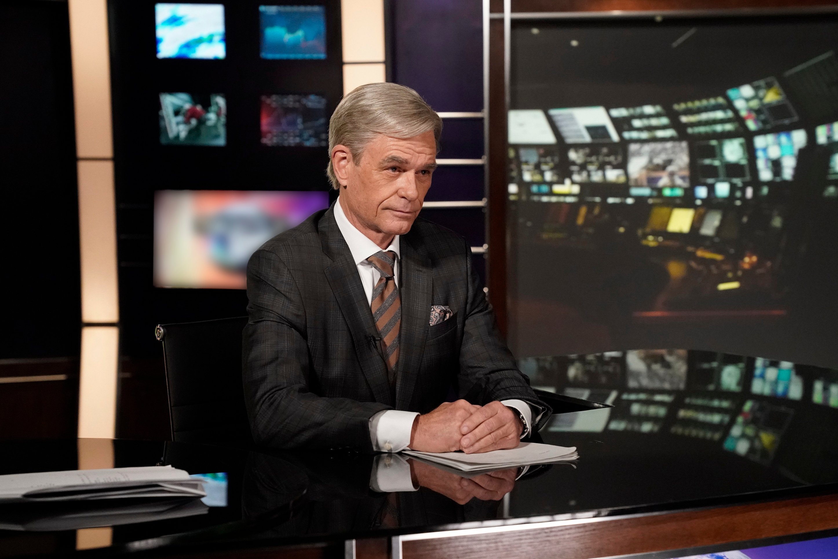 Harry Hamlin as Tom Brokaw, sitting behind an anchor desk, in 'The Hot Zone: Anthrax'