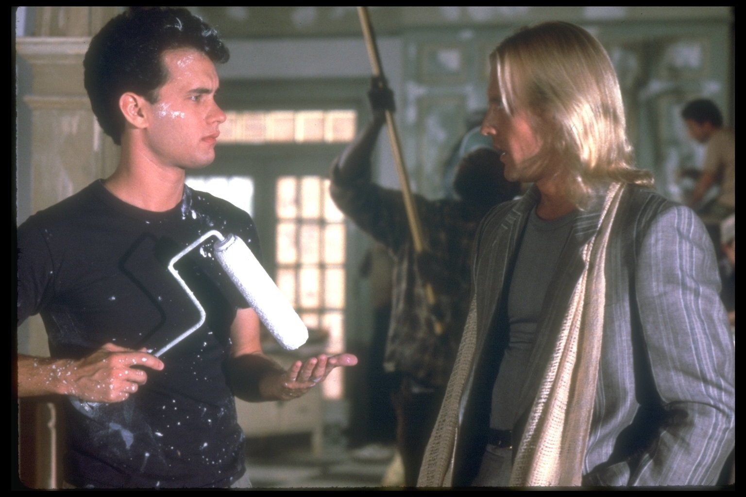 Tom Hanks holds a paint roller while Alexander Godunov talks