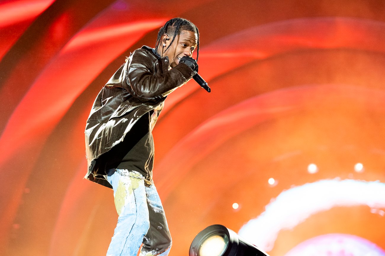 Travis Scott performing in front of orange background at Astroworld Festival 2021