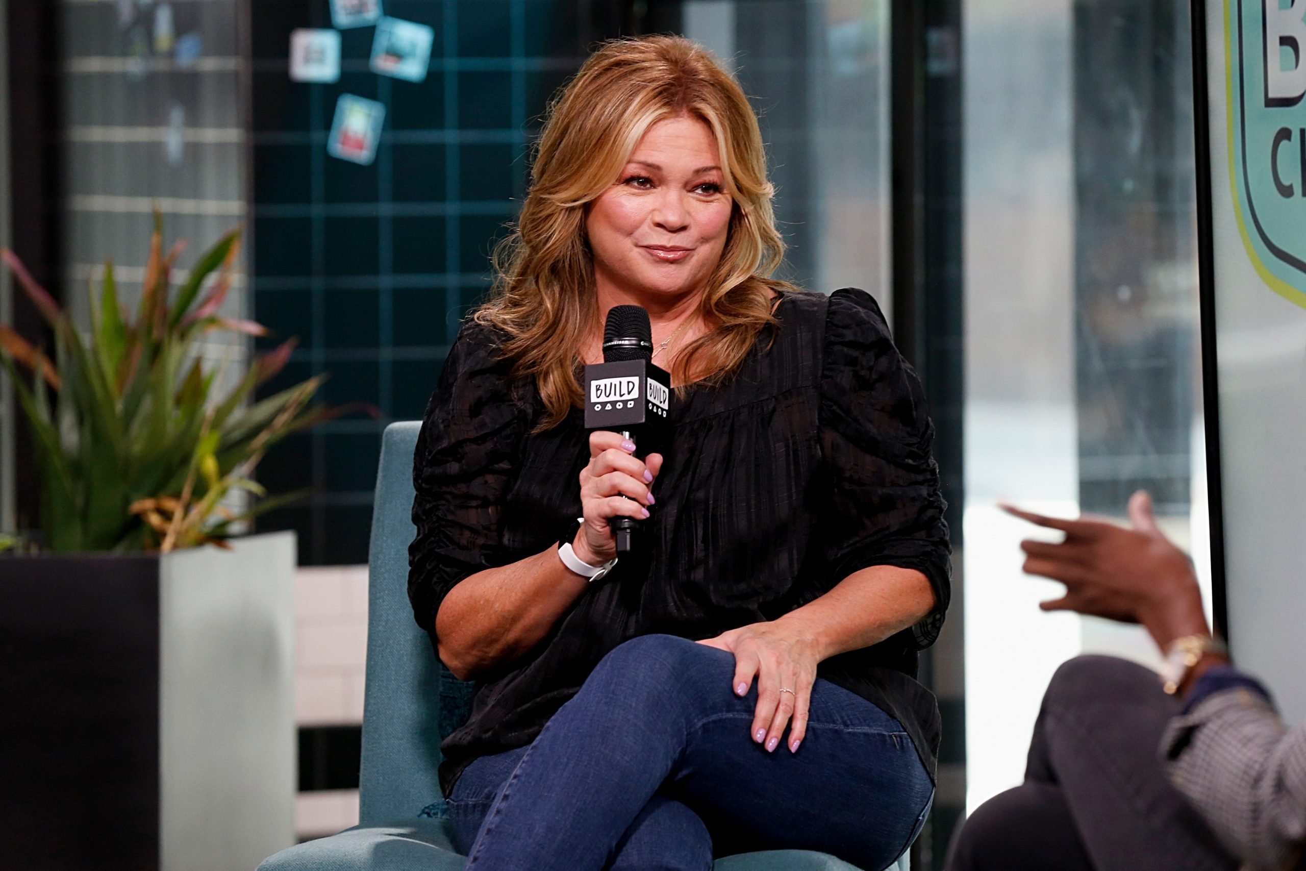 Food Network host Valerie Bertinelli smiles as she speaks into a microphone at a 2019 Food Network event.