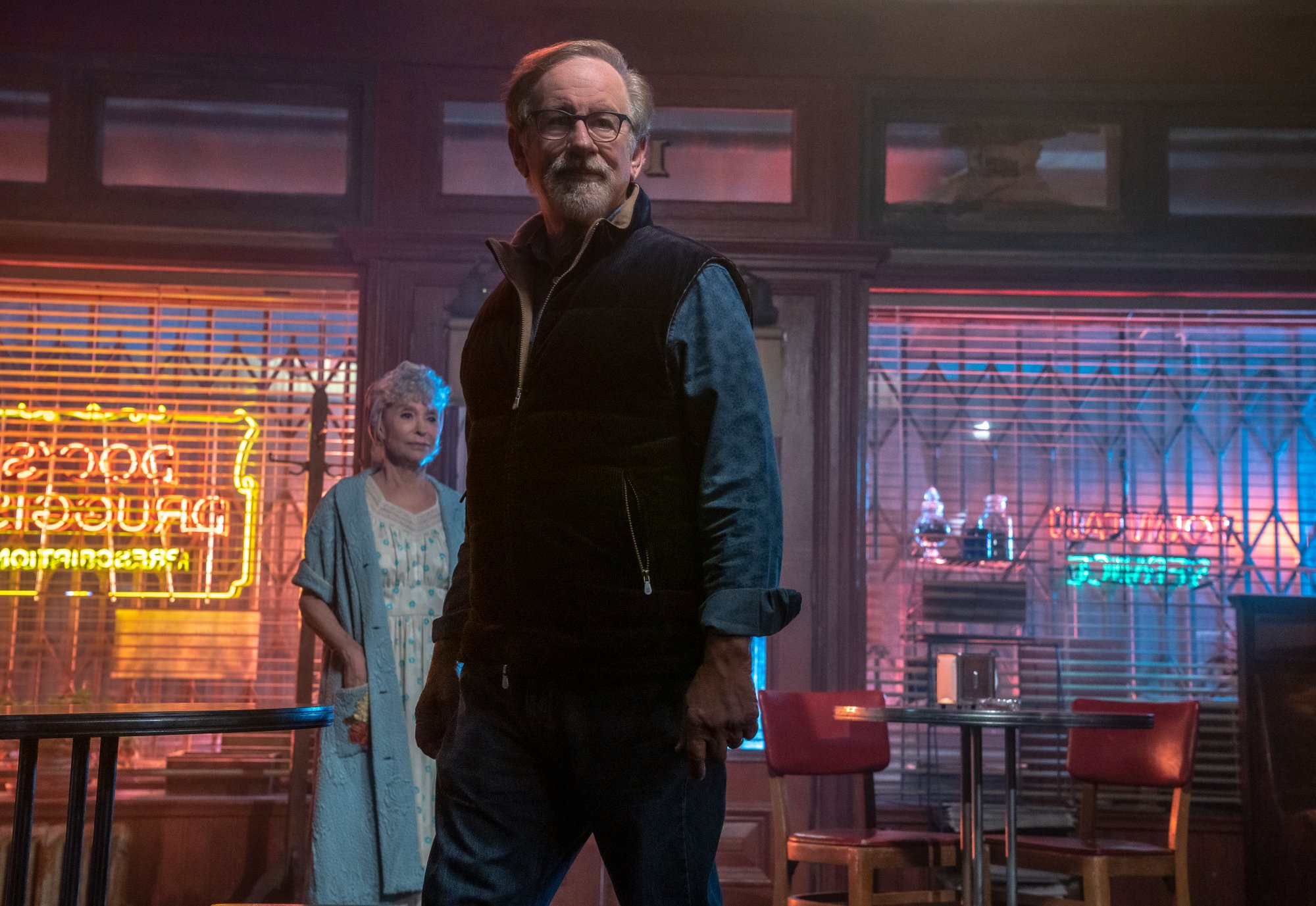 'West Side Story' Steven Spielberg and Rita Moreno as Valentina standing on the set with neon lights in the background