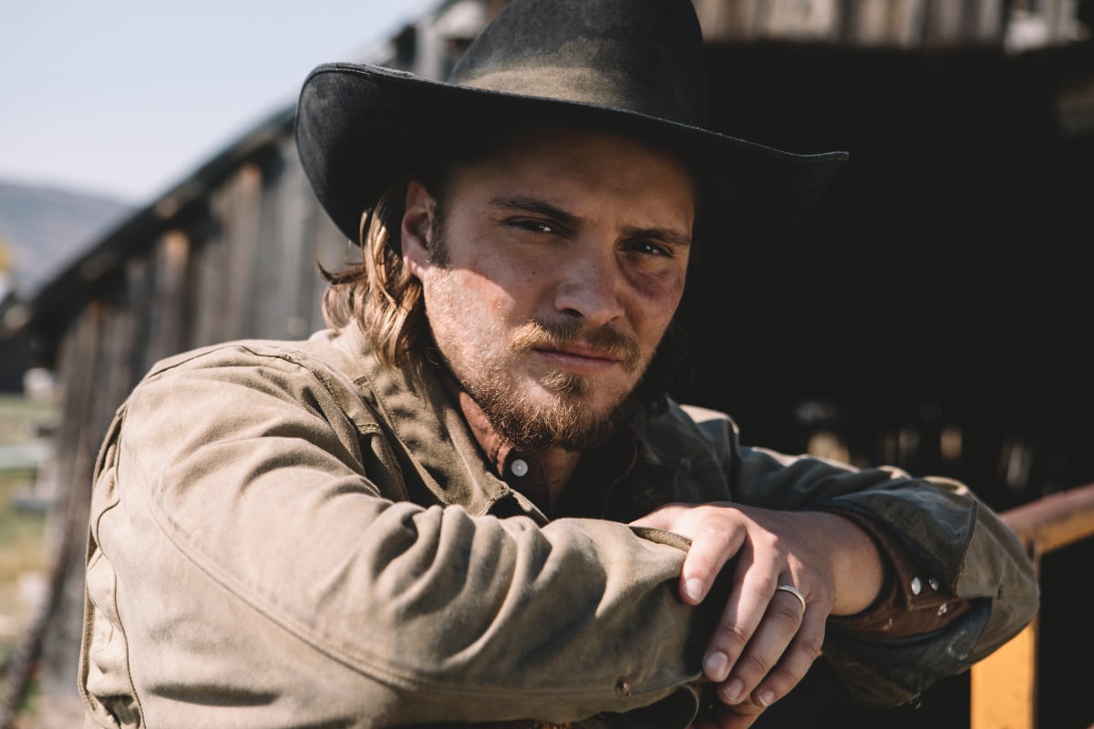 Luke Grimes as Kayce Dutton in Yellowstone. Kayce is wearing a brown hat and coat.