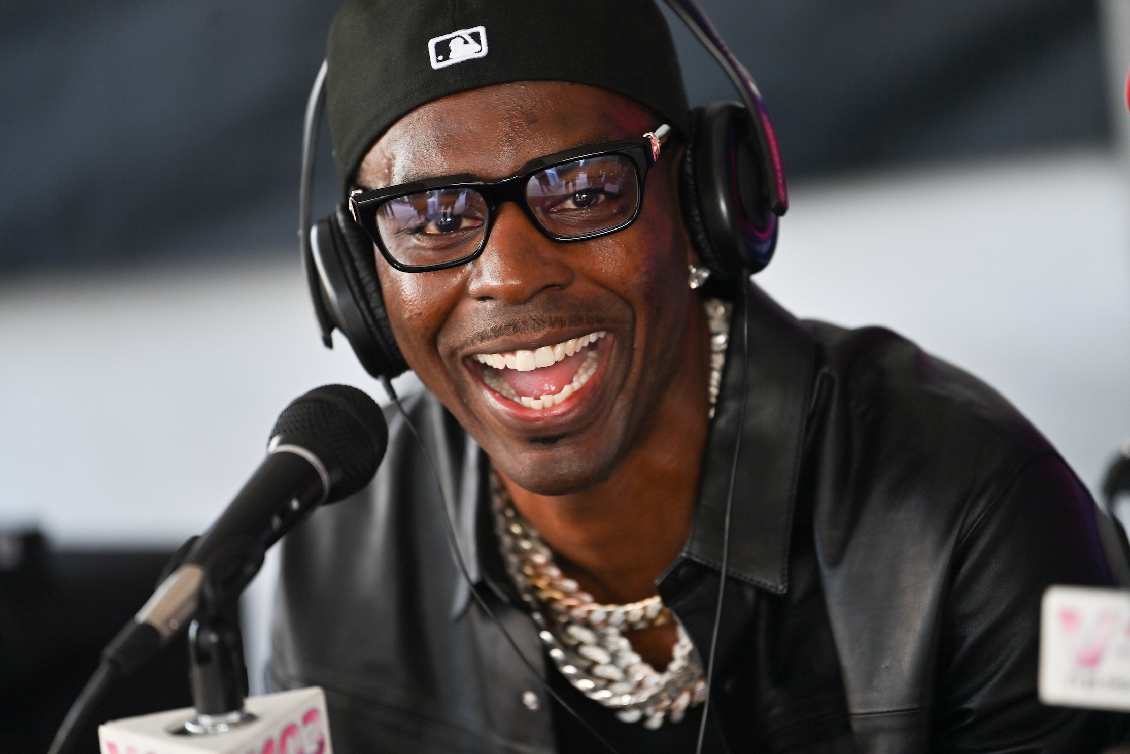 Rapper Young Dolph laughing in front of a microphone. Young Dolph attained a high net worth by the time he died in 2021.