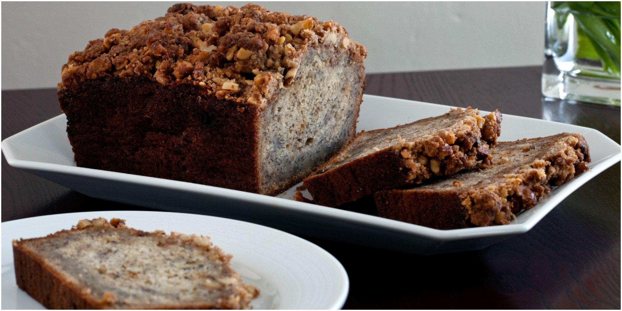 A sliced loaf of banana bread on a white plate.