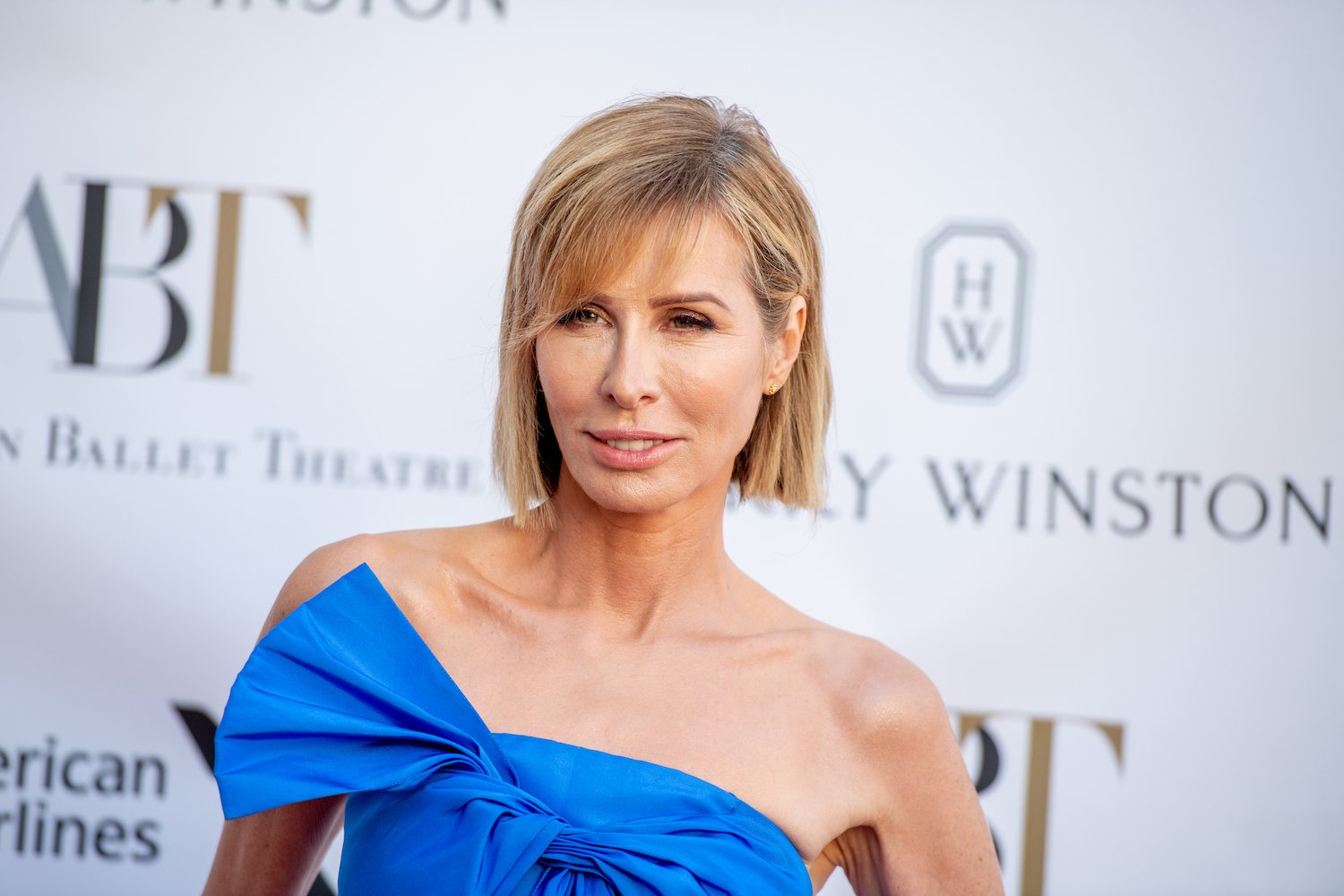 Carole Radziwill smiling in a blue dress.