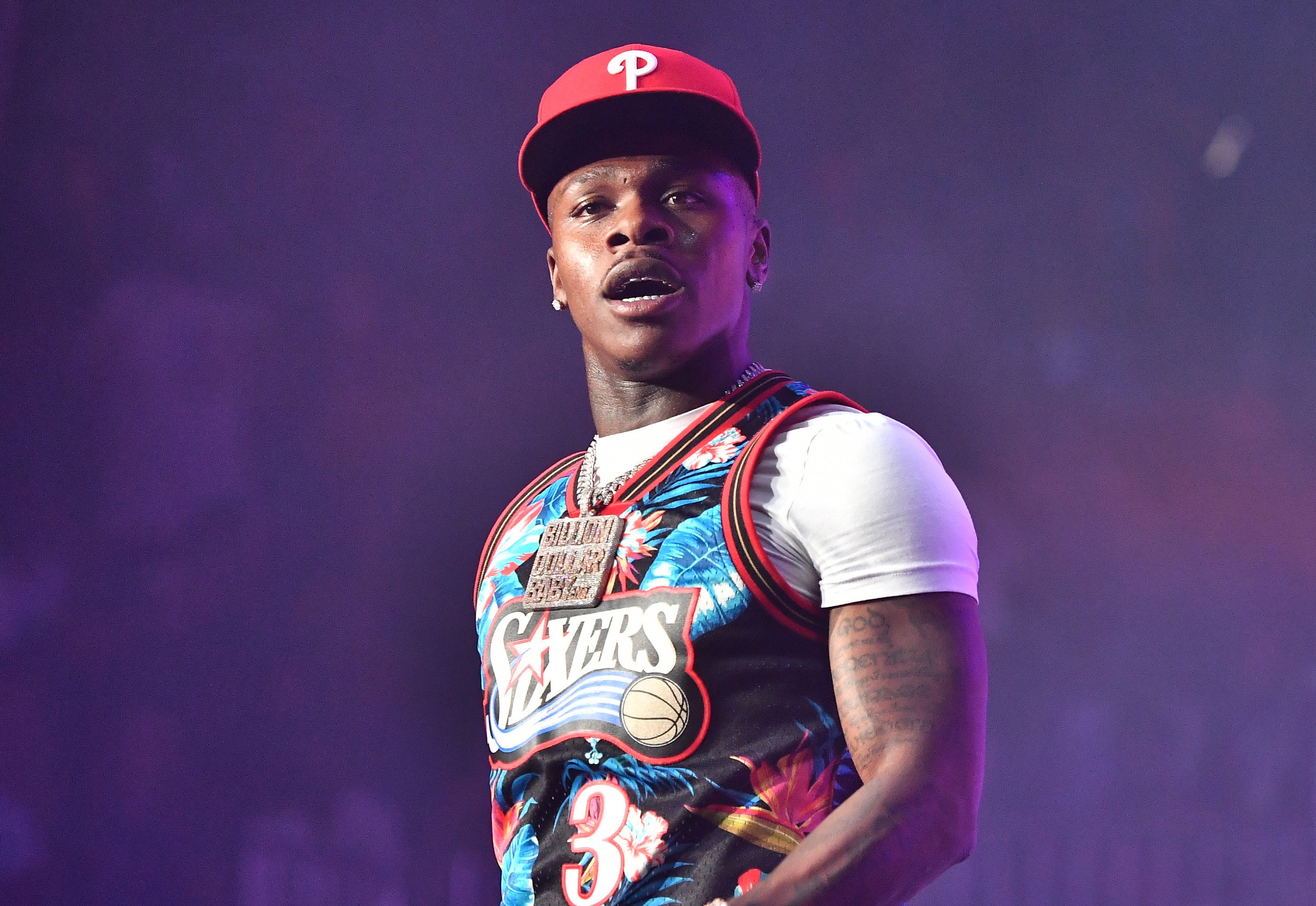 DaBaby wearing a red hat while performing on stage.