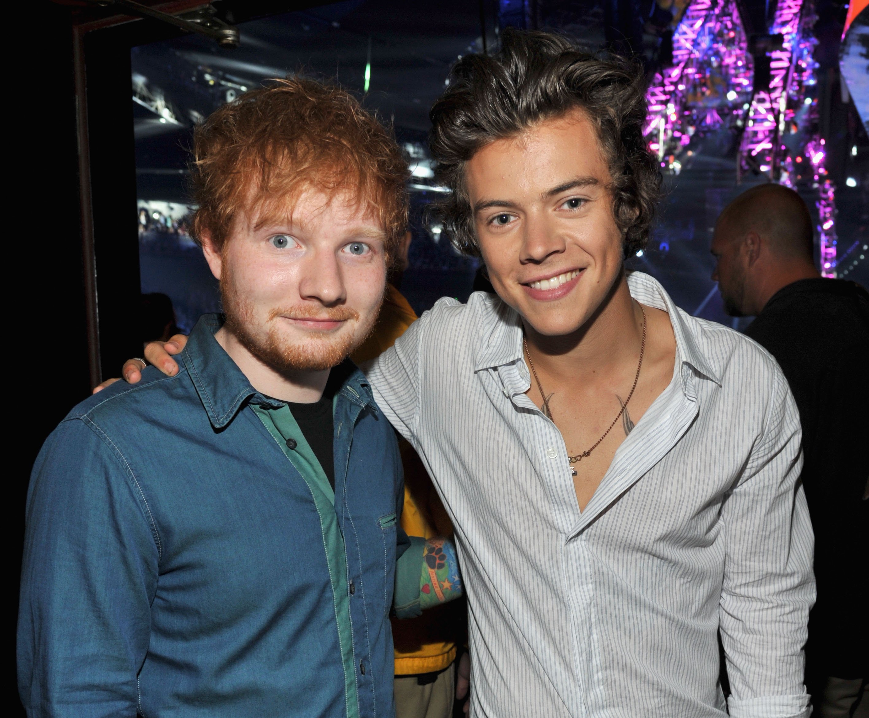 Ed Sheeran putting his arm around One Direction's Harry Styles