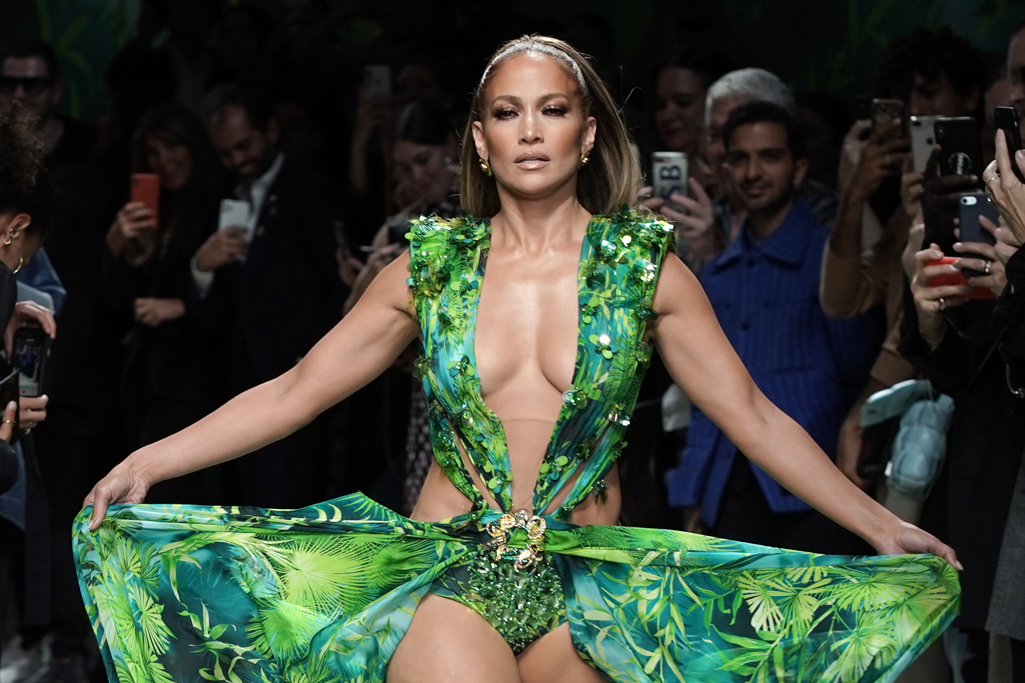 Jennifer Lopez walks the runway in a green dress.