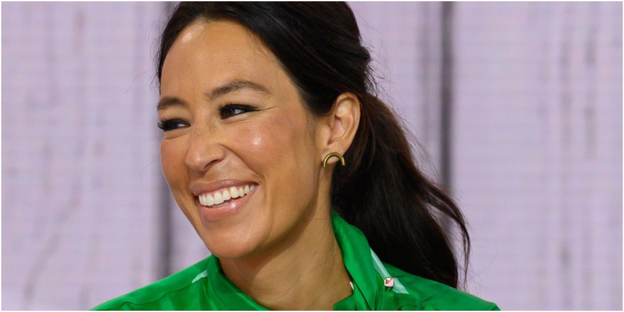 Joanna Gaines smiles for the camera wearing a green outfit.