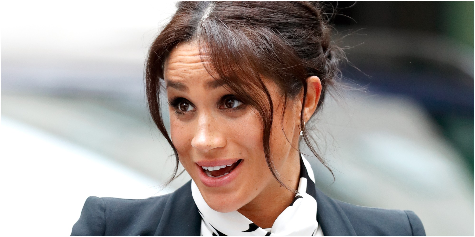 Meghan Markle poses for a red carpet photograph with her hair tied away from her face.