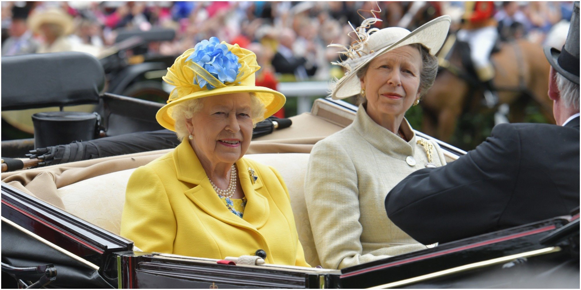 Queen Elizabeth and Princess Anne ride in a horse drawn carriage.