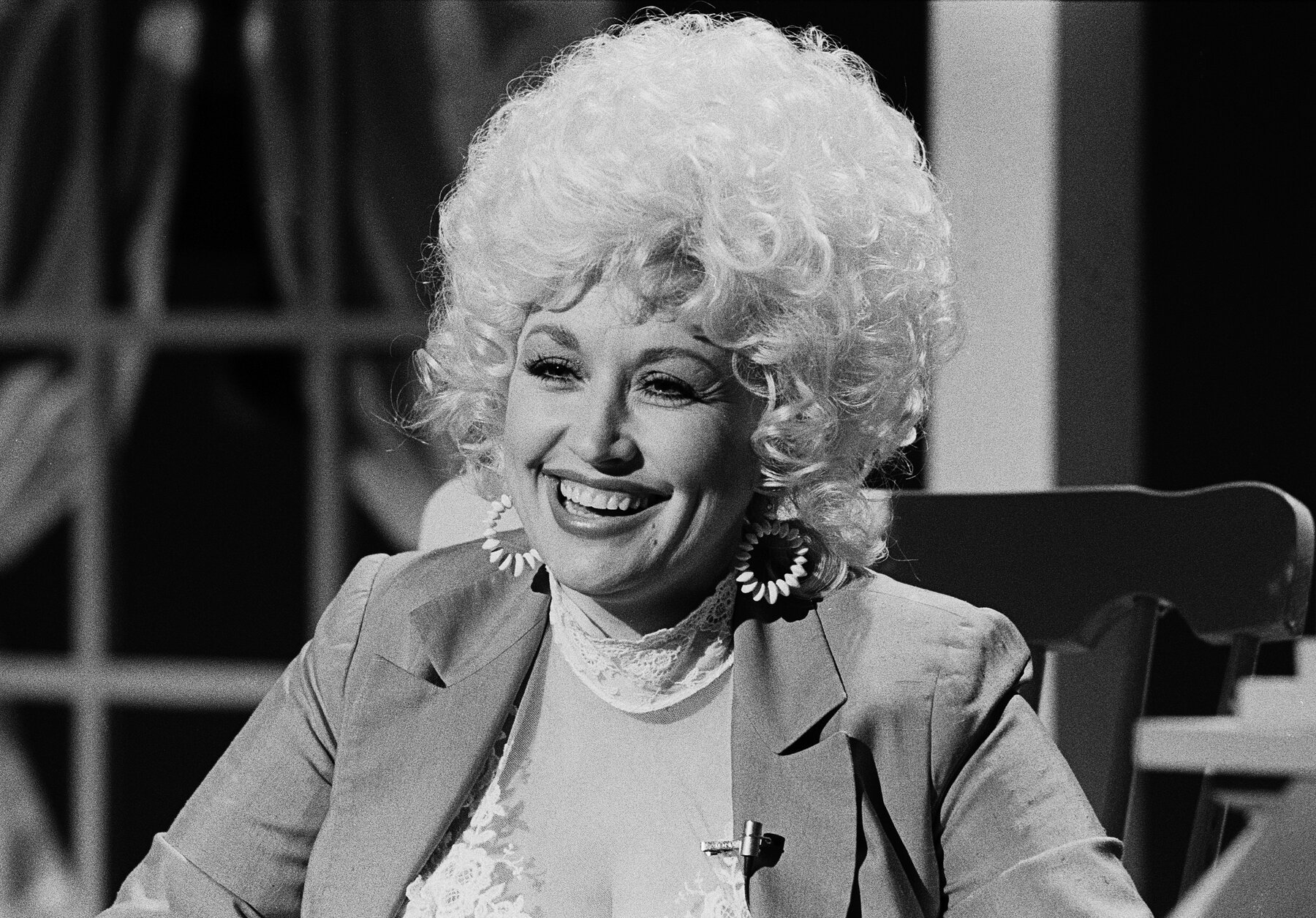 Dolly Parton sits on stage
