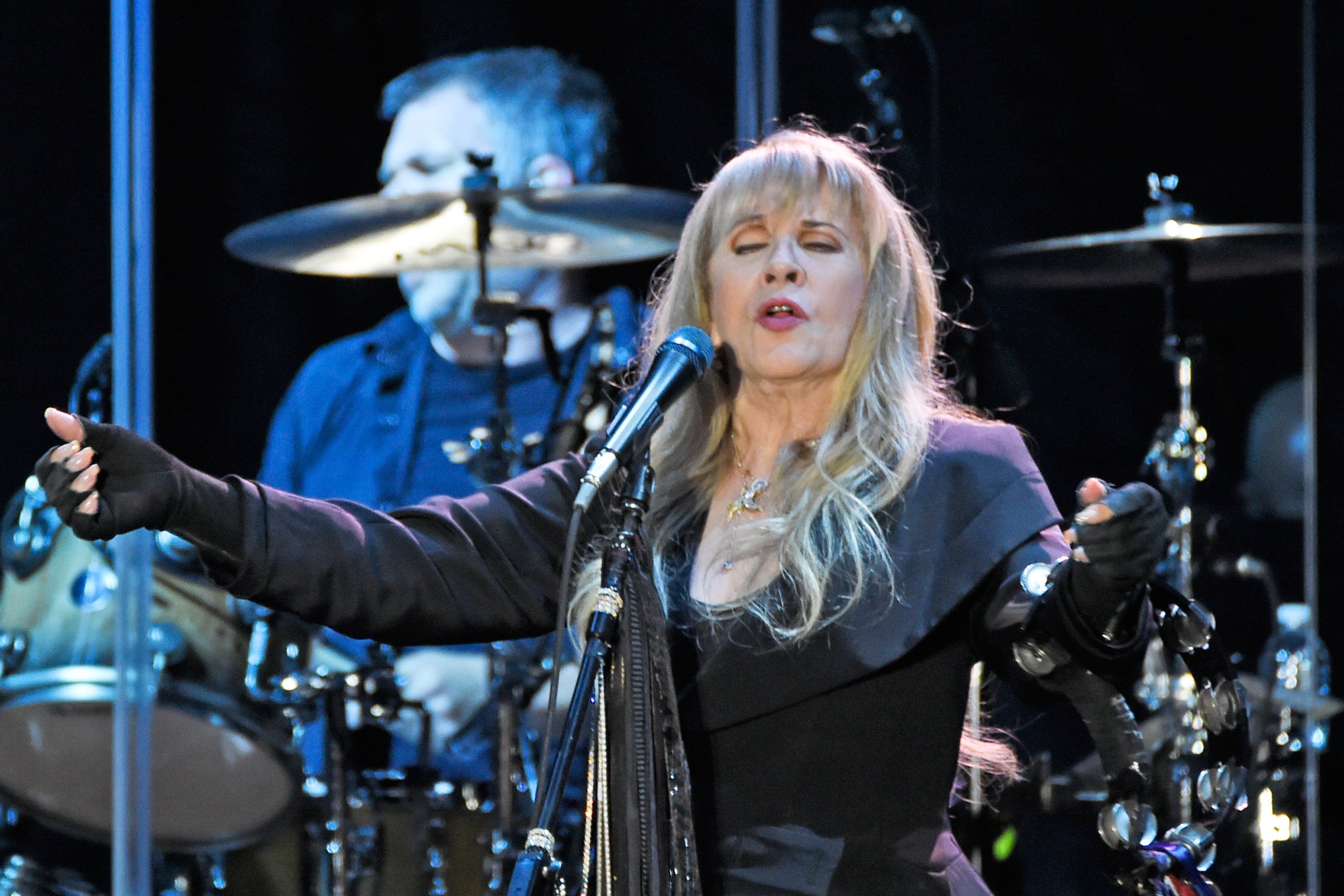 Stevie Nicks wears a black outfit while performing.