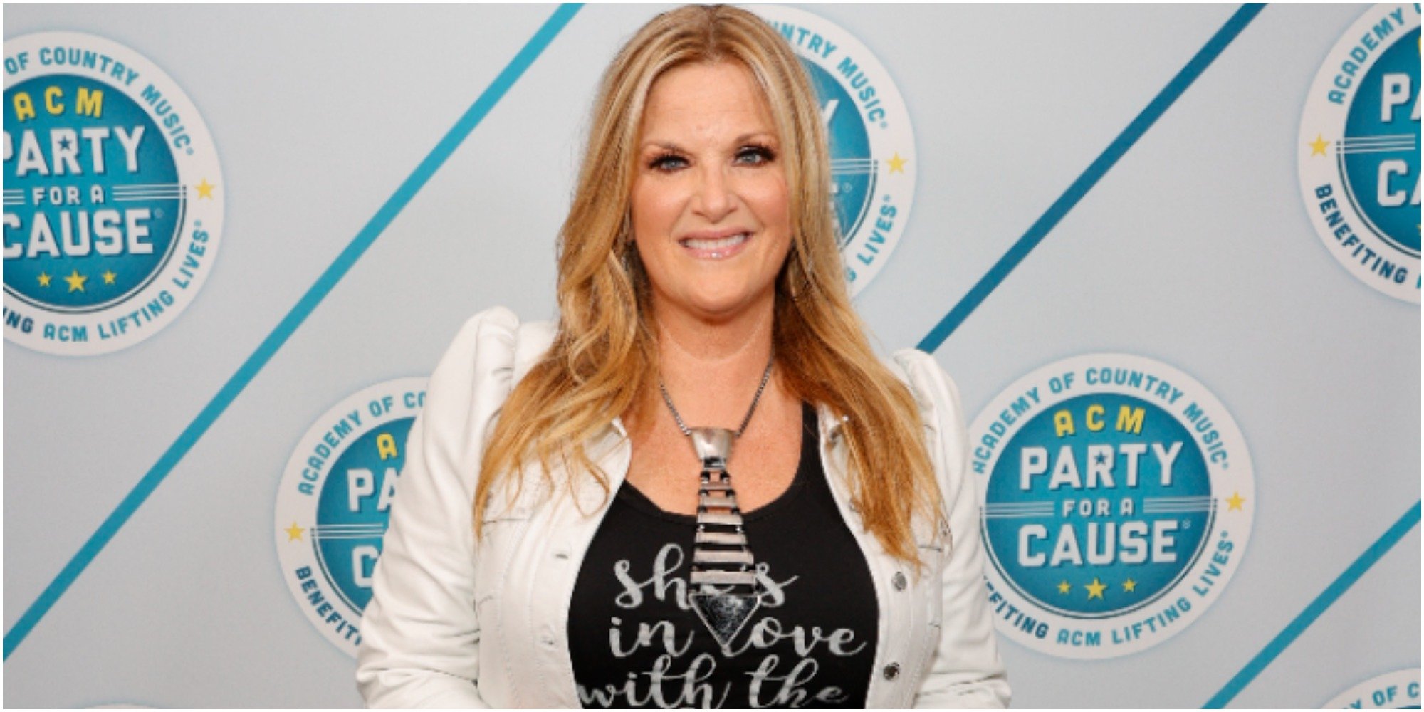 trisha yearwood smiles for the cameras on the red carpet.