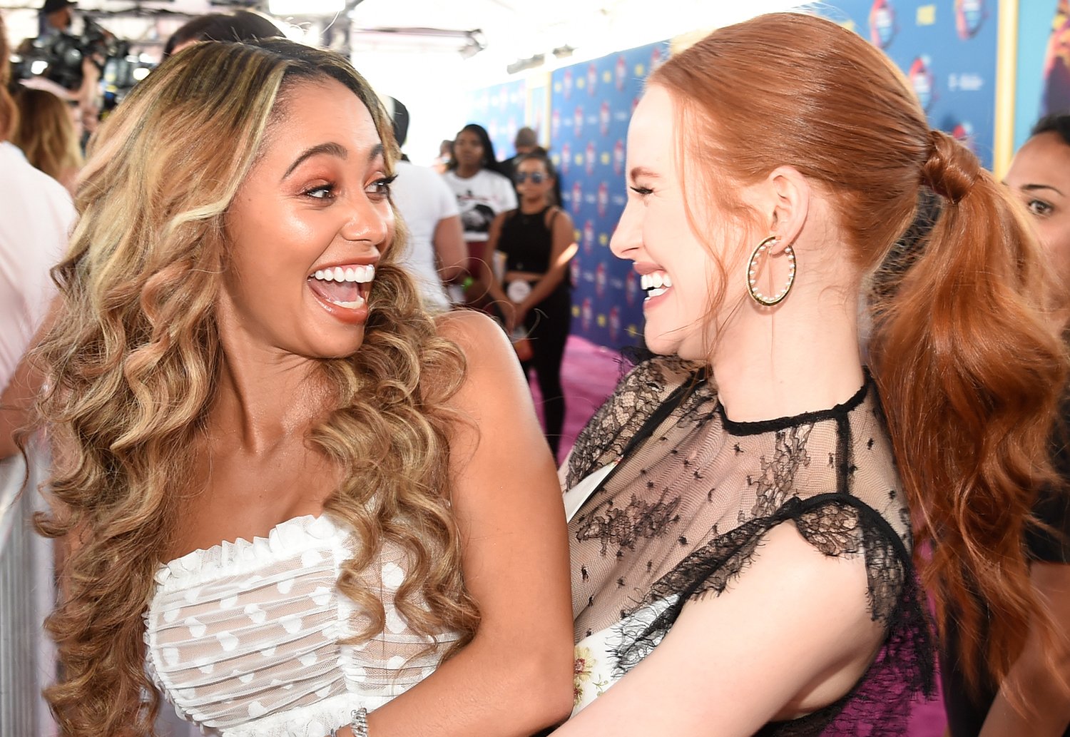 Riverdale stars Vanessa Morgan, who plays Toni Topaz, and Madelaine Petsch, who plays Cheryl Blossom, hugging at the 2018 Teen Choice Awards