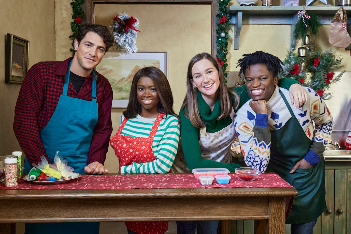 The cast of 'A Godwink Christmas: Miracle of Love' standing behind a kitchen island