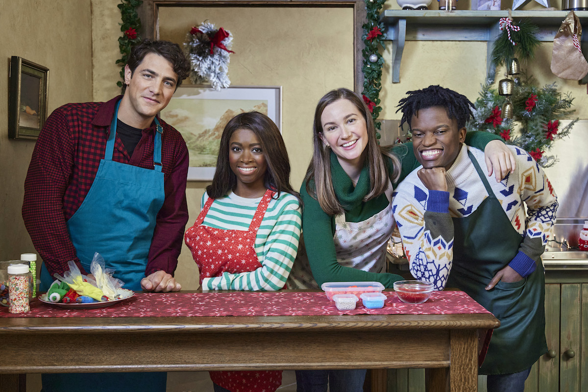 The cast of 'A Godwink Christmas: Miracle of Love' standing behind a kitchen island