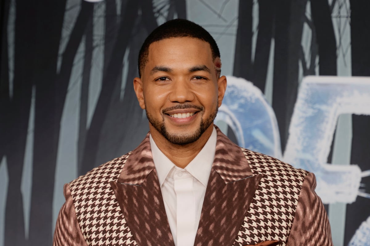 Alano Miller attends the world premiere of Dexter: New Blood Series at Alice Tully Hall, Lincoln Center on November 01, 2021 in New York City. Miller is wearing a printed suit and smiling.