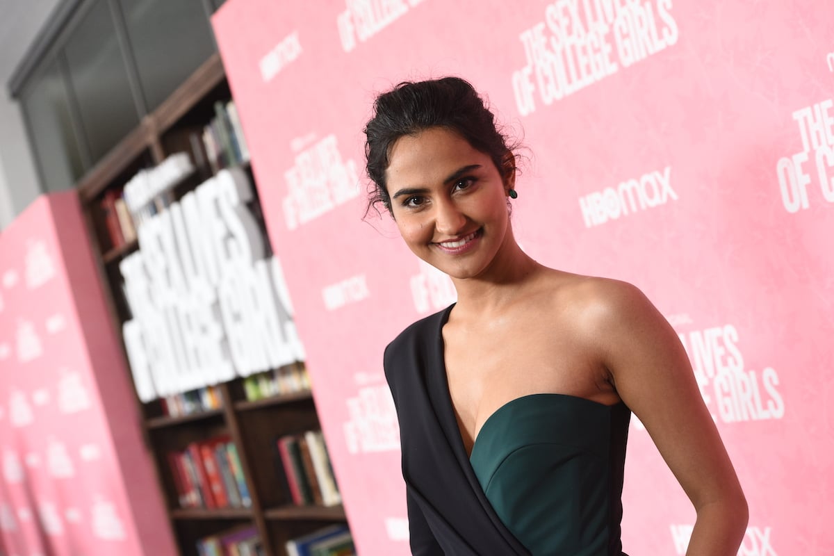 Amrit Kaur smiling in front of a pink background