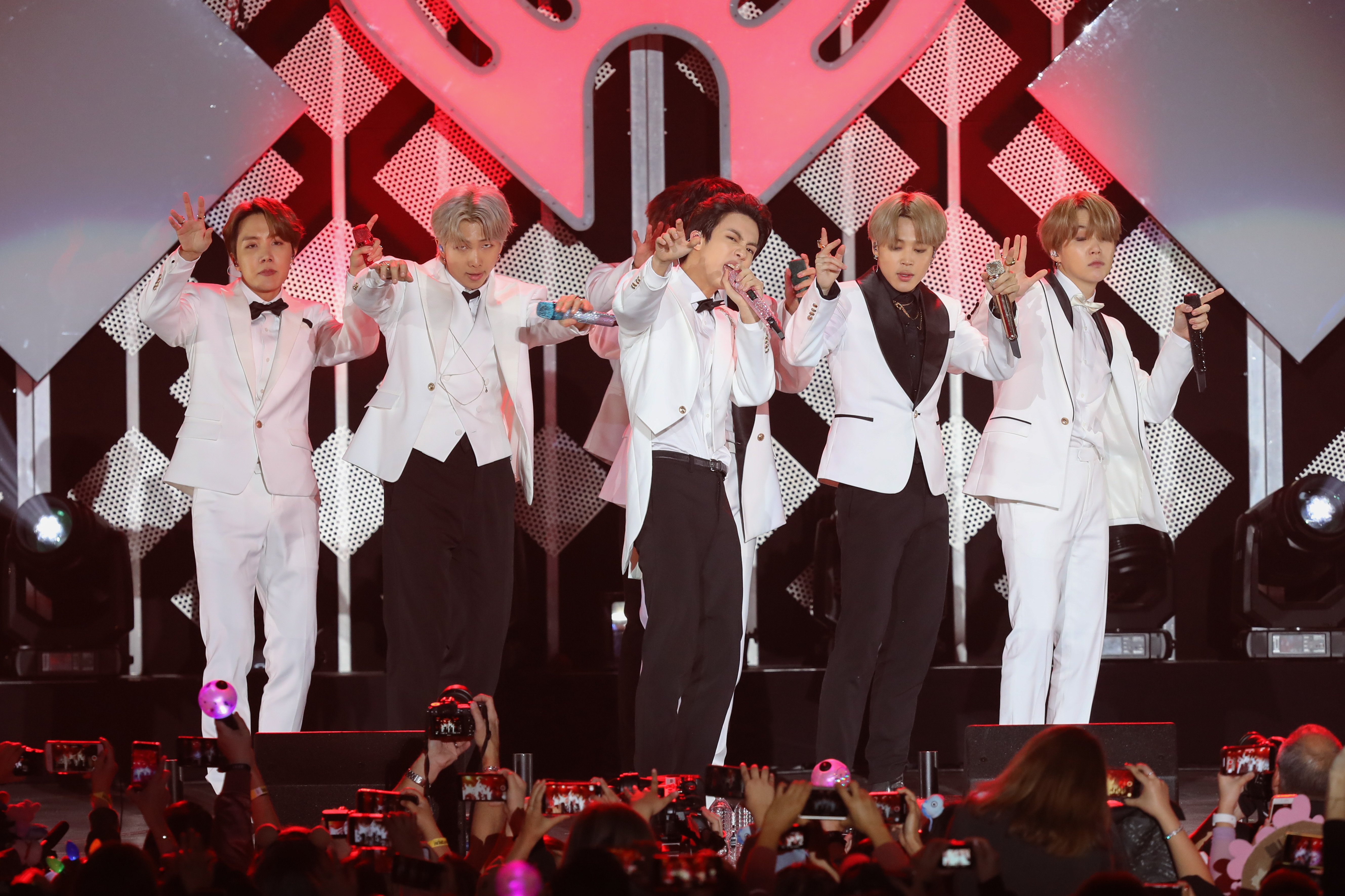 V, Suga, Jin, Jungkook, RM, Jimin, and J-Hope of BTS performs during the iHeartRadio KIIS FM's Jingle Ball dressed in white shirts and black and white pants