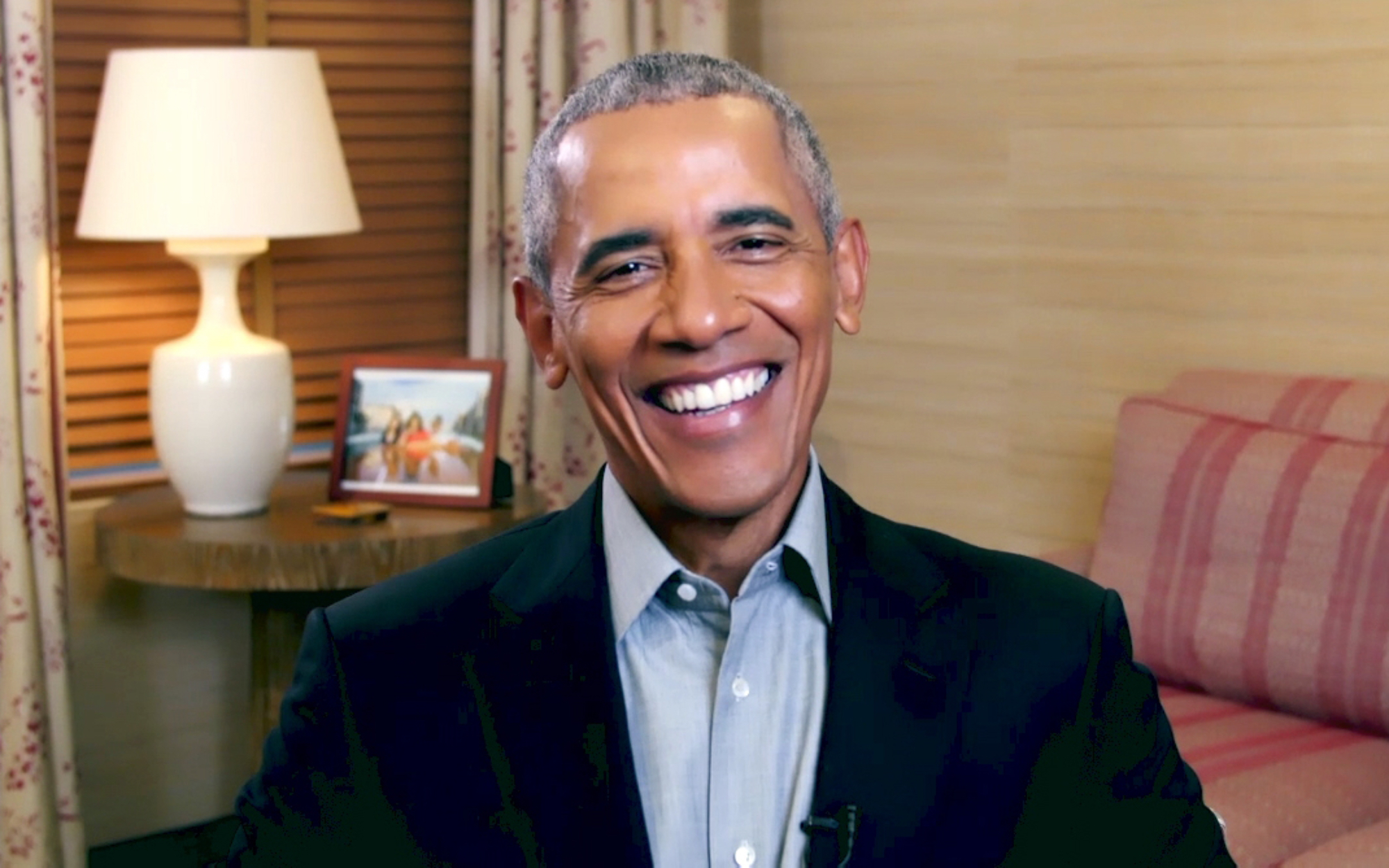 Barack Obama featured in his favorite movies of 2021 smiling in front of a picture frame