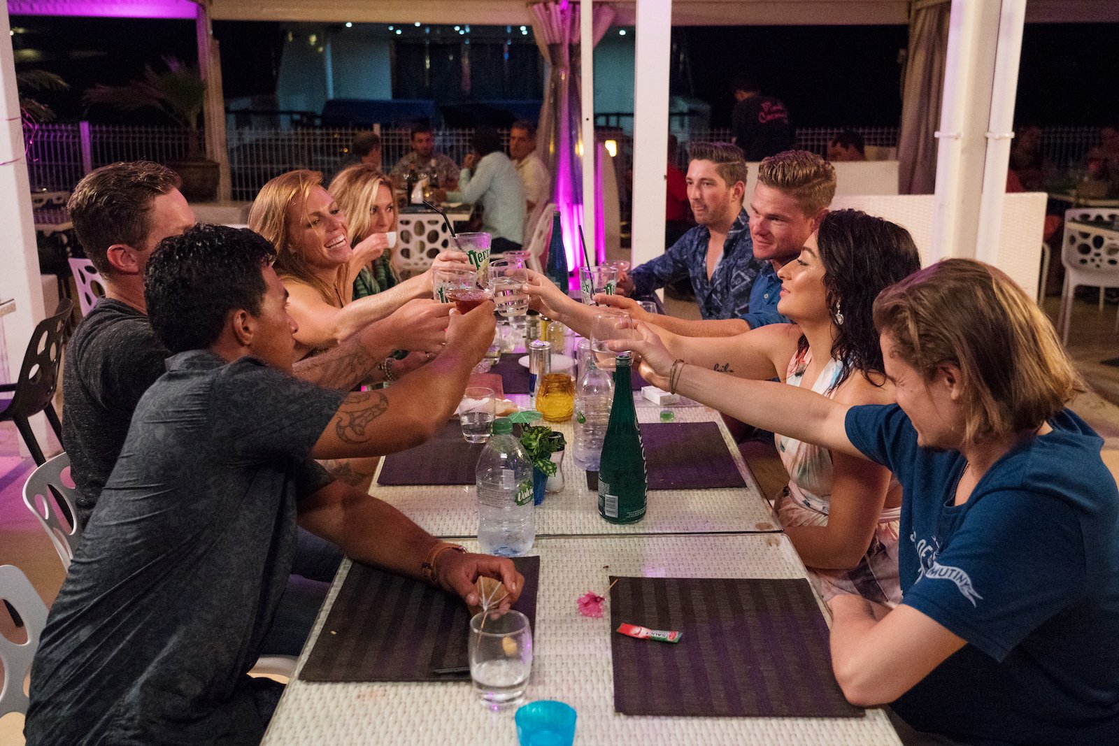 Below Deck crew clink cocktail glasses during a crew night out: Ross Inia, Rhylee Gerber, Kate Chastain, Josiah Carter, Ashton Pienaar, Laura Betancourt, Adrian Martin