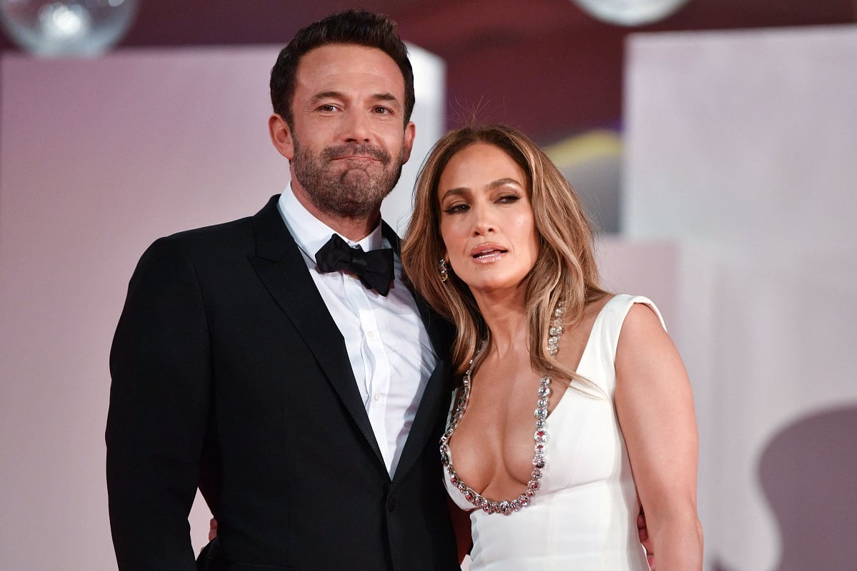 Ben Affleck and Jennifer Lopez posing together while dressed up.