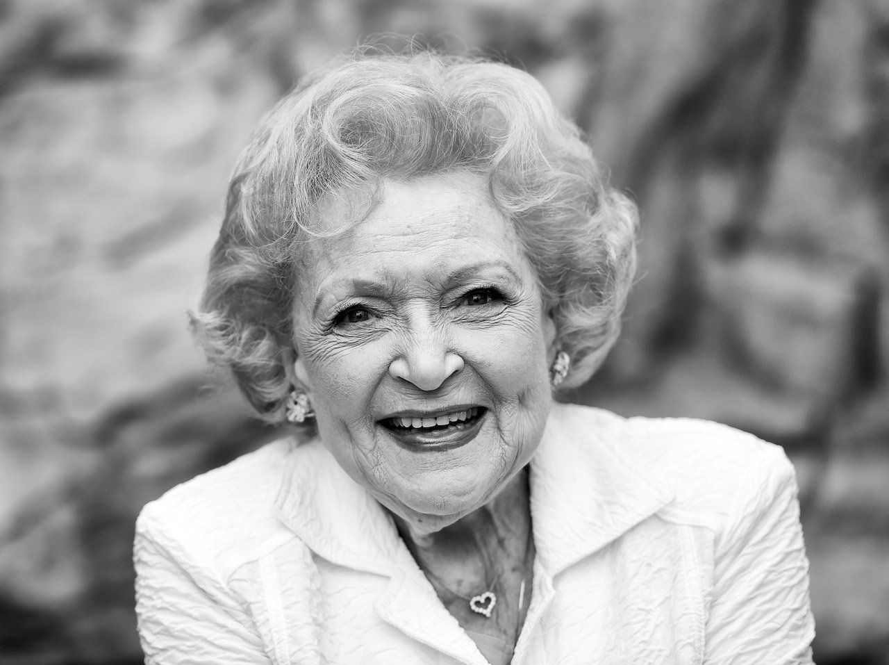 Betty White smiles in a black and white photo.