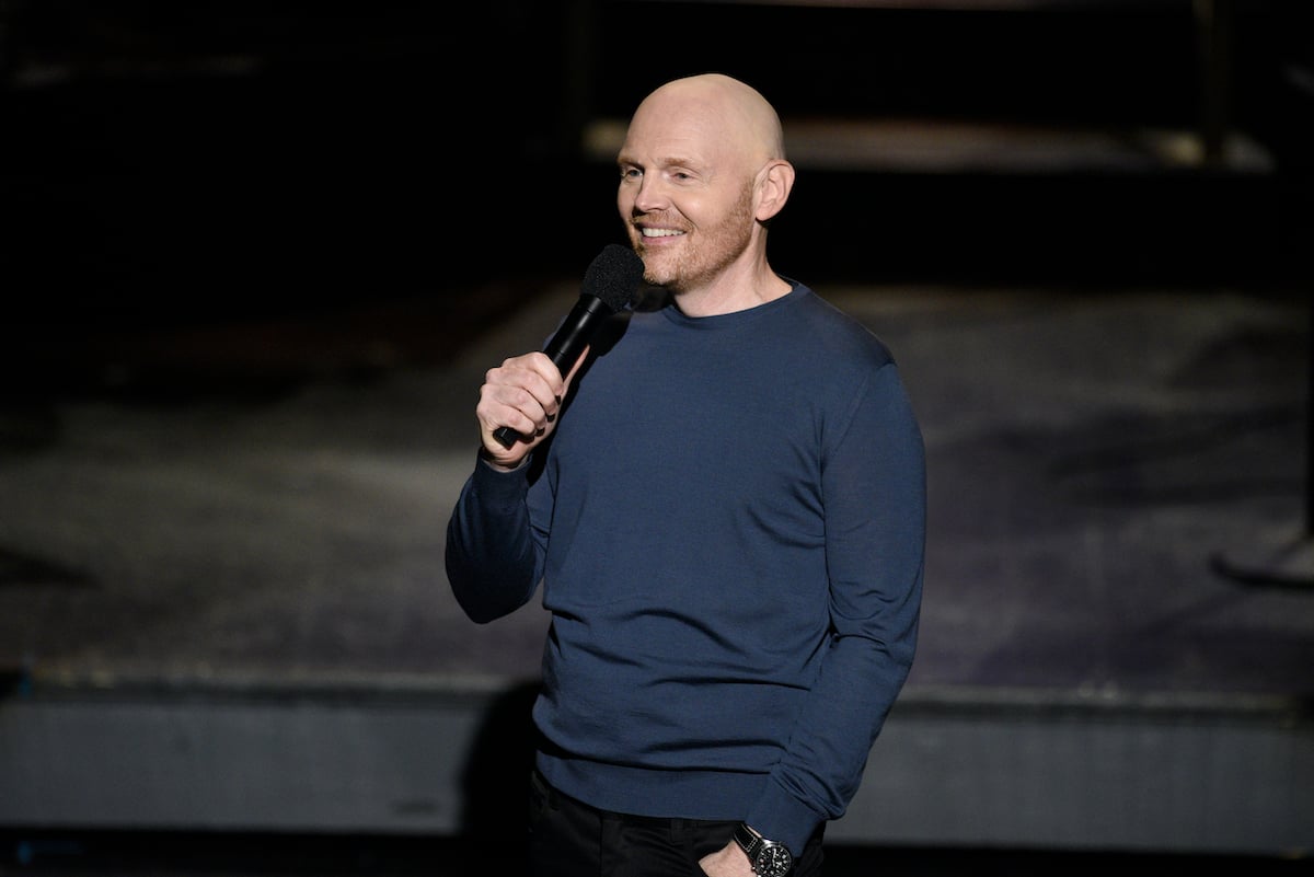 Bill Burr smiling, holding a microphone