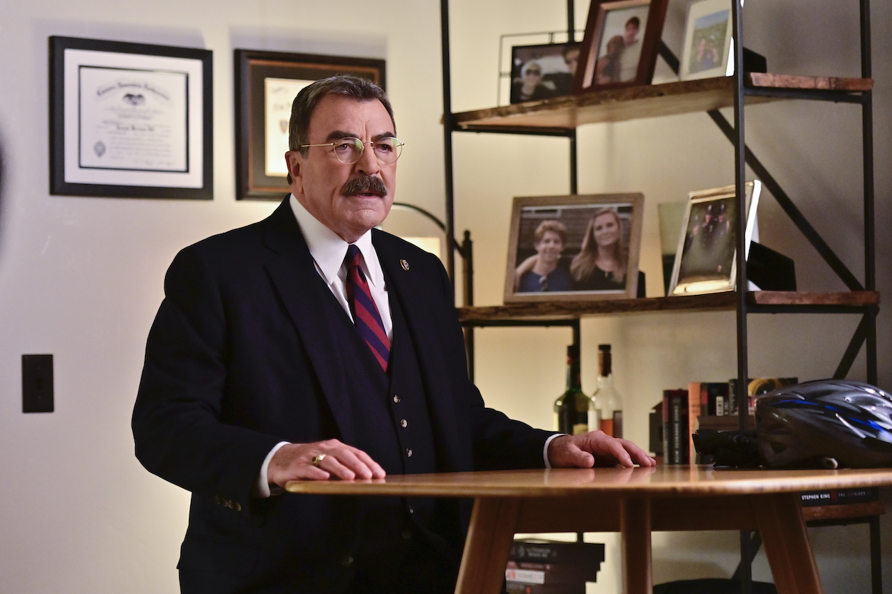 Tom Selleck as Frank Reagan on 'Blue Bloods' sits at a table in Joe's home.