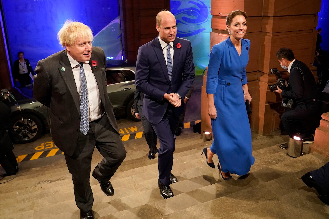 Boris Johnson, Prince William, and Kate Middleton walk up a flight of stairs