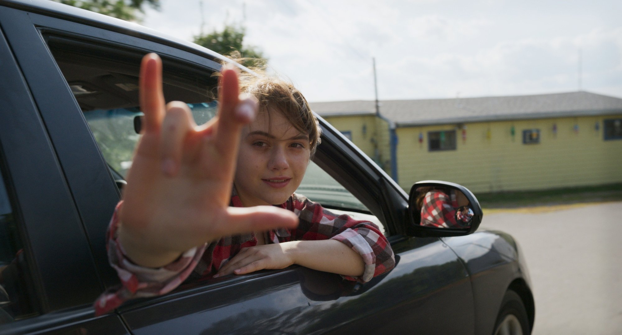 'CODA' Emilia Jones as Ruby signing out of the window of a moving car
