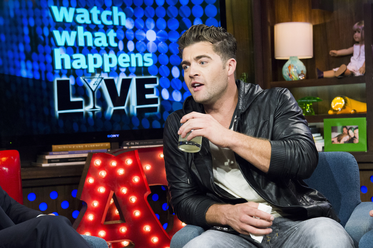 CT Tamburello from MTV's 'The Challenge' Season 37 sitting on a couch and taking a drink of water on 'Watch What Happens Live.' 