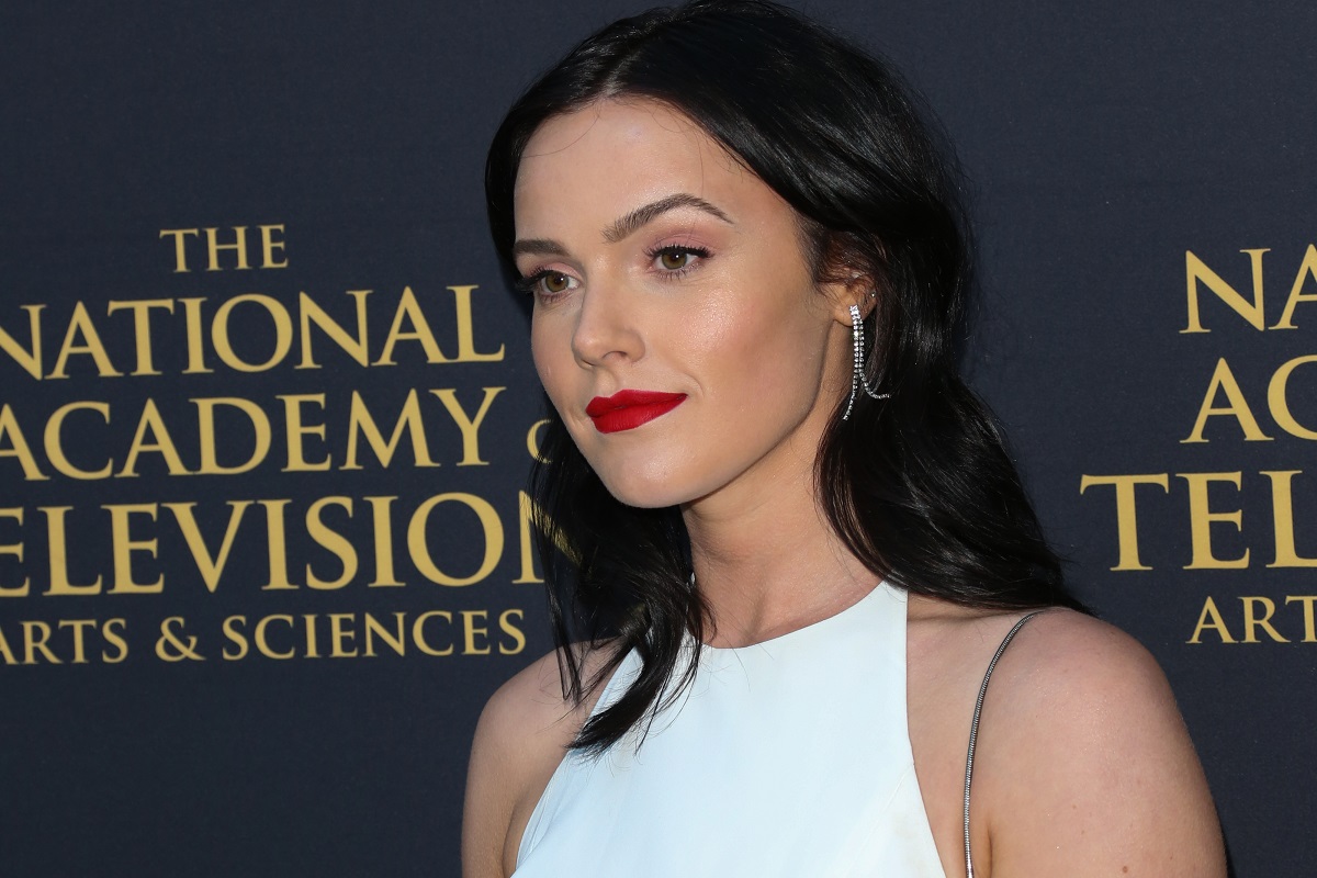 'The Young and the Restless' actor Cait Fairbanks wearing a white dress and red lipstick.