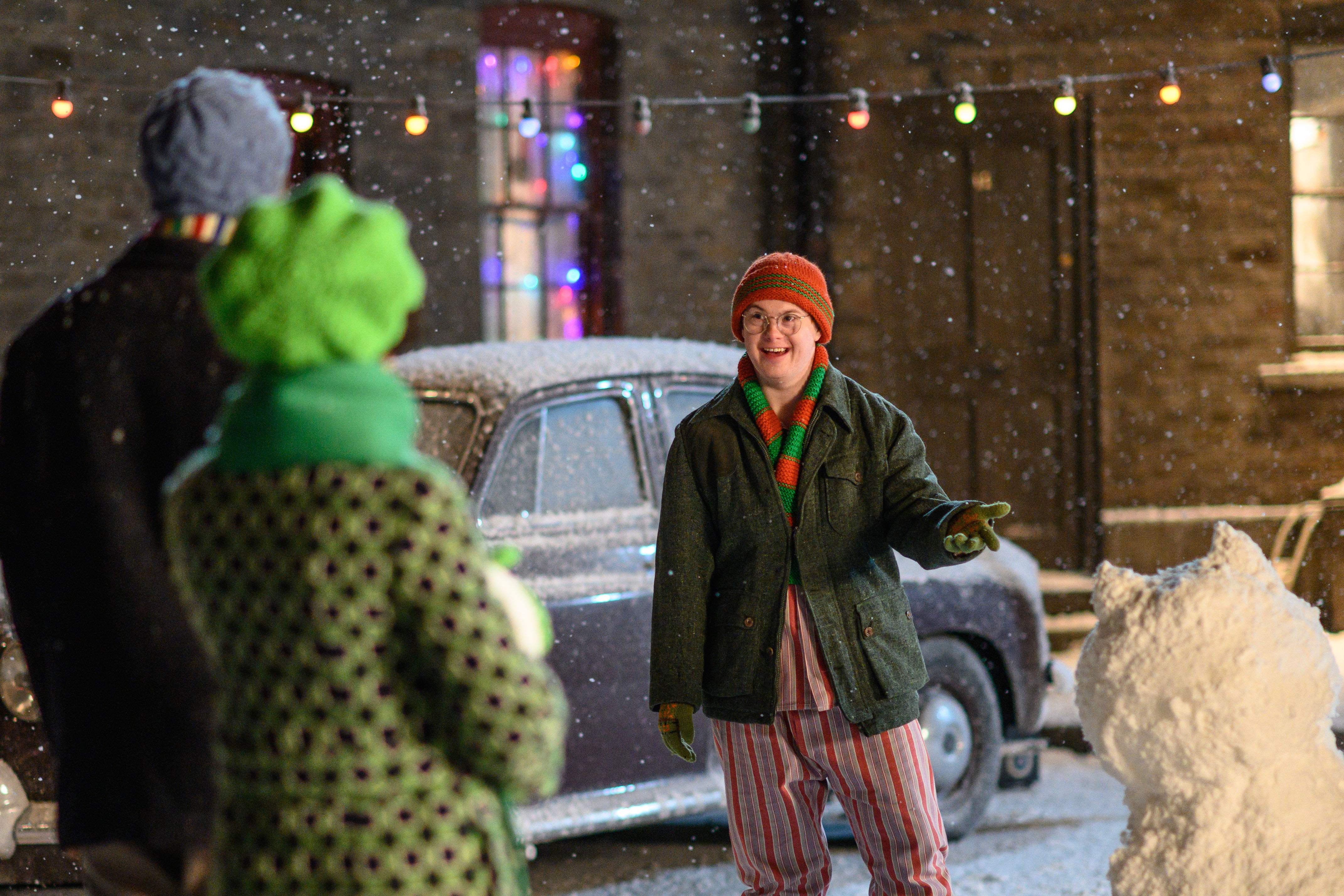 Reggie standing in the snow facing Cyril and Louise, with their backs to the camera, in the 2021 'Call the Midwife' Christmas special